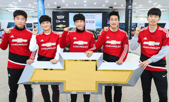 맨유 연수 프로그램에 초청된 5명의 인천지역 고등학교 축구부 학생들이 쉐보레 엠블럼 뒤에서 포즈를 취하고 있다. <한국GM 제공>